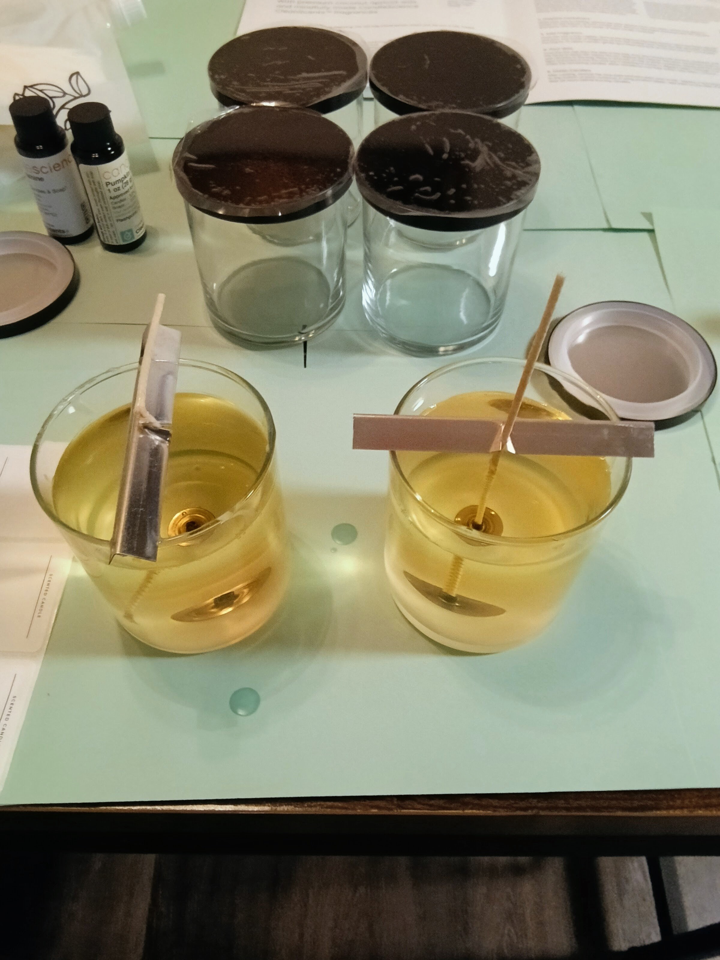 Pouring golden melted wax into glass jars